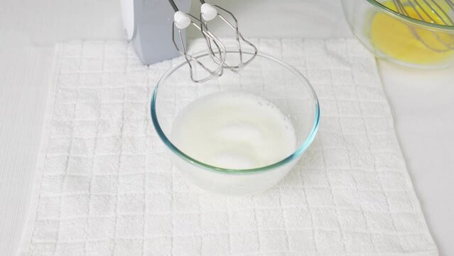 A man adds a tablespoon of sugar to a whipped protein to meringue. High quality 4k footage