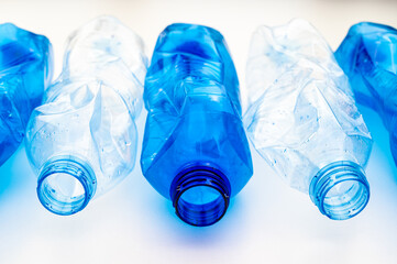 Plastic bottles, blue and transparent, crushed. Waste and plastic pollution, plastic recycling. 
