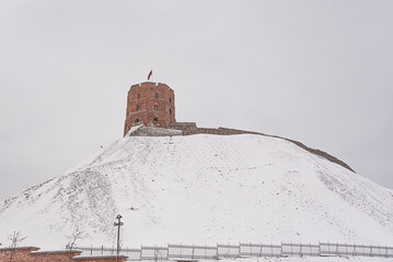  View of Gediminas Tower on a snowy winter morning as seen from Sventaragis Valley park below, Old Town Vilnius, Lithuania - obrazy, fototapety, plakaty