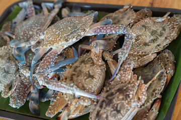 Wood Plate with a deliciouse raw seafood crabs, ready to grill or cook