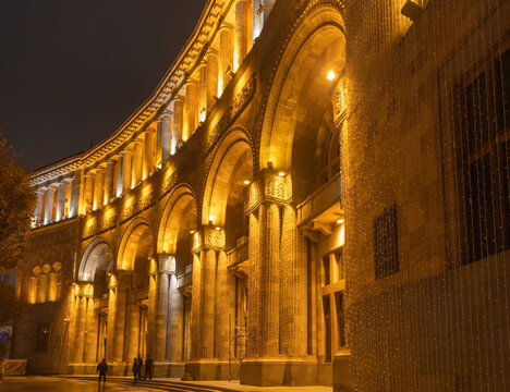 Government House in the center of Yerevan in the evening, lit with warm yellow colors.