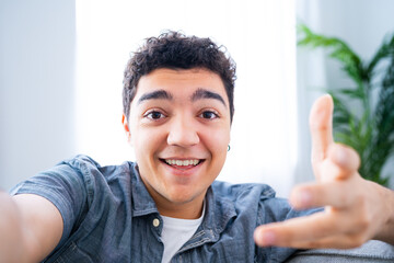 Hispanic teenager boy talking to camera. Influencer live streaming or having video call