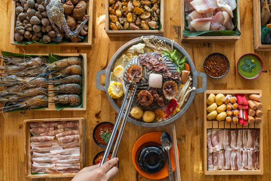 Wood Table with deliciouse seafood, shrimp, crab, mussle, pork saussage and vegetable in bbq grill restaurant from thailand