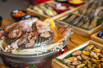 Wood Table with deliciouse seafood, shrimp, crab, mussle, pork saussage and vegetable in bbq grill...