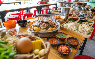 Wood Table with deliciouse seafood, shrimp, crab, mussle, pork saussage and vegetable in bbq grill restaurant from thailand