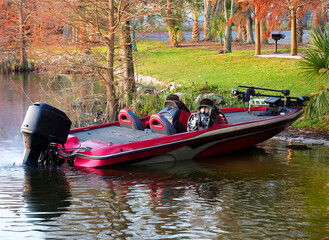 A Powerful Bass Boat Tied Up to the Lake Shore In the Early Morning Light - 567064401