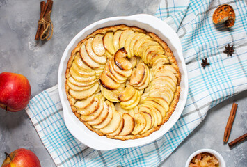 Homemade delicious fresh baked rustic apple pie on concrete background, top view
