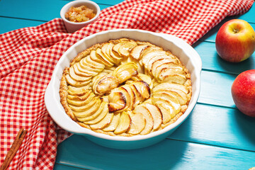 Homemade delicious fresh baked rustic apple pie on blue wooden background