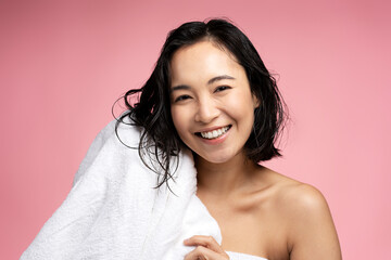 Horizontal shot of attractive female wipes wet hair with towel