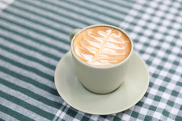 hot cappuccino with latte art on wood background