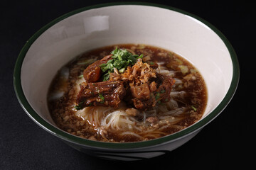 Braised pork noodles Thai street food isolated in black background