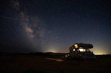 Motorhome RV parked under stars on a pier by the sea, Crete, Greece.