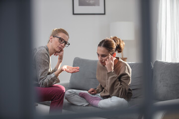 Mother talking with difficult teenager daughter at home.