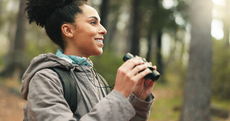 Hiking, forest and woman with binocular watch nature scenery, view or bird watching while trekking...
