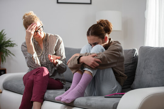 Mother talking with difficult teenager daughter at home.