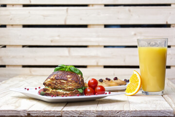 Sandwich with cheese and tomato with orange juice on a wooden background