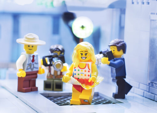 Lego minifigure of actress like Marilyn Monroe over a  subway grate. A skirt is blowing. Editorial illustrative image of popular plastic toys brand.