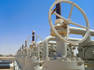Oil and gas industry pipelines with valves, construction site.