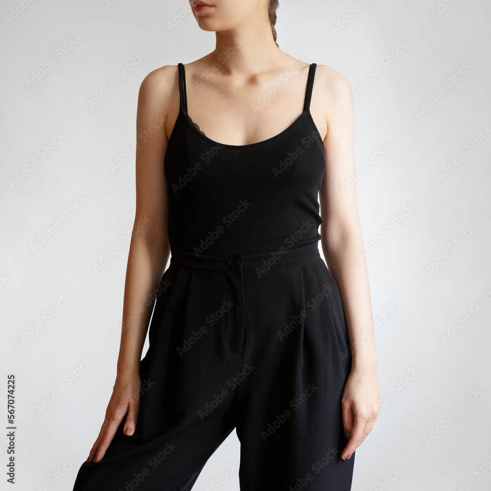 Wall mural Woman wearing black top and black pants isolated on white background