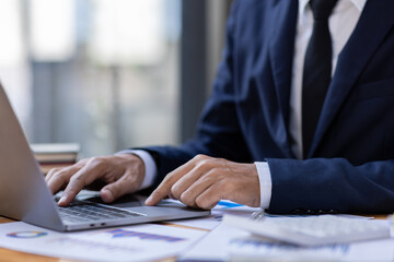 Businessman accountant or financial expert analyze business report graph and finance budget chart in the office. Concept of finance economy, banking business and stock market research.