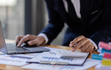 Businessman accountant or financial expert analyze business report graph and finance budget chart in the office. Concept of finance economy, banking business and stock market research.