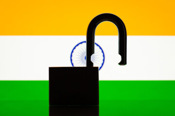 Reopen India, tourism, open borders concept. Flag of India with open lock on the foreground