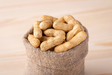 Small bag full of unpeeled peanuts. Tasty fresh nuts close up