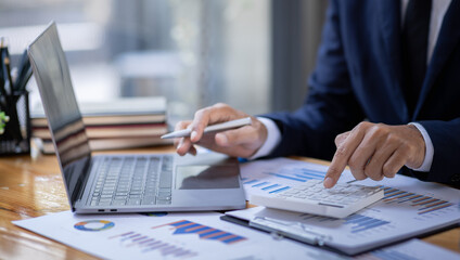 Businessman accountant or financial expert analyze business report graph and finance budget chart in the office. Concept of finance economy, banking business and stock market research.