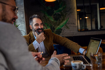 Two businessman having a business meeting in cafe.