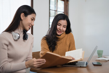 Happy Asian college students studying together in the roo. Education concept. .