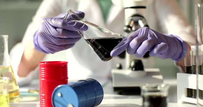 Laboratory testing of crude oil in flask in scientist hand