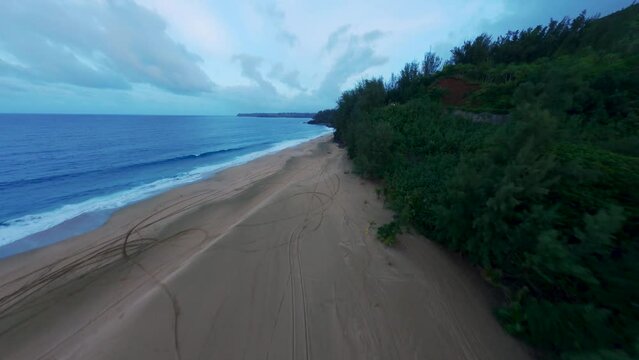 Cinematic drone shot of amazing white sand beach and lush green foliage with blue waters. Hanalei Bay, Kauai, Hawaii, USA. 4K UHD