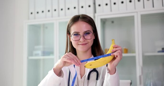 Doctor plastic surgeon holds a banana and measuring tape in hands
