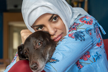 Arabian Muslim Hijab Woman Play Stroking Her Favorite Pet Dog Dachshund Breed. Concept Of Friendship With Pet, Care, Veterinarian Health Wellbeing Animal