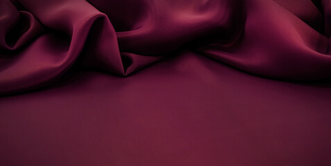 Texture of a smooth luxurious, elegant fabric in burgundy, purple, red. Purple satin or silk fabric with folds and waves