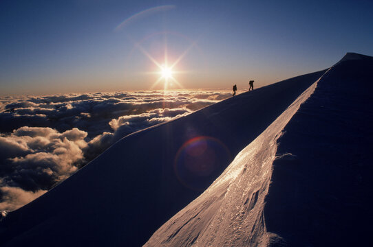 Two mountaineers silhouetted by the setting sun, New Zealand.