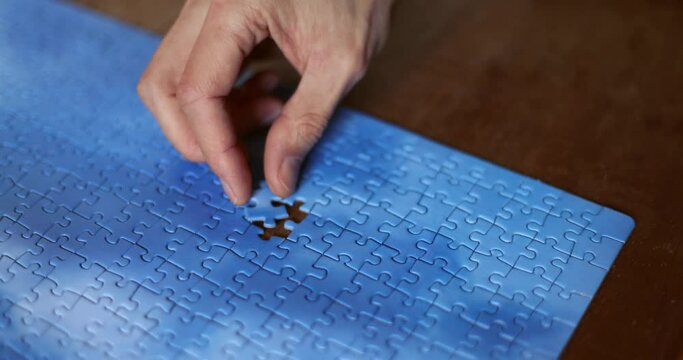 The missing piece of the sky puzzle, the concept of completing a big job, the final of the project, the successful solution of business problems. The hand puts the last piece of the jigsaw