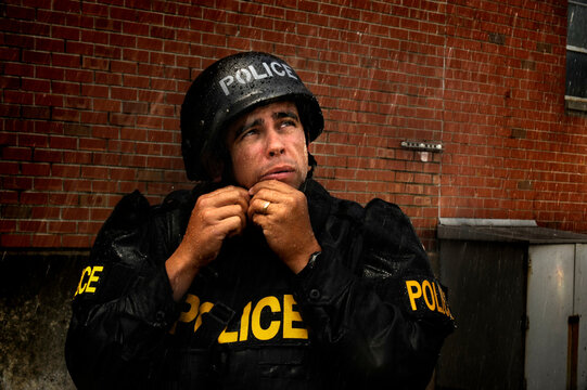 A Special Weapons and Tactics (SWAT) member shows how police officers must work in all weather by conducting operation in simulated rain.