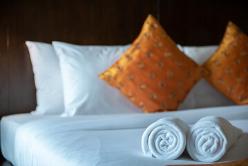 Soft pillows and white towel on clean white bed. Pillows bed with bedding sheets in bedroom. Bed sheets and pillows messed. Hotel, resort or home can relax on bed for deep sleep.