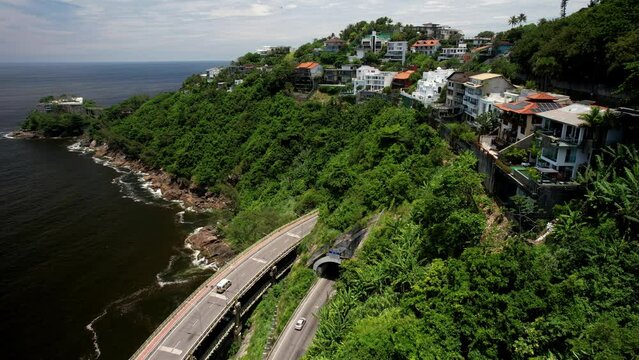 Aerial drone view of luxurious houses overlooking the Elevado do Joa in Rio de Janeiro, Brazil, a complex of tunnels, bridges and viaducts that connects the south and west zones of the city