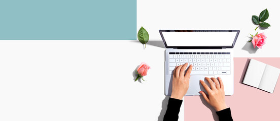 Woman using her laptop with pink roses