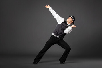Confident young man dancing in gangster style suite.