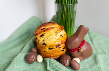Homemade Easter traditional pastries lie on a green napkin with a bouquet of flowers, a rabbit,...