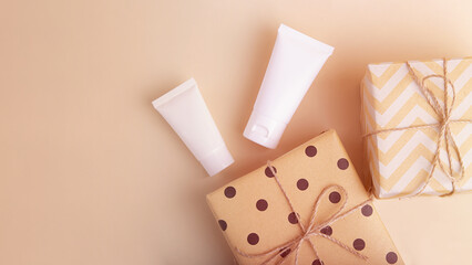 Top view of blank cosmetics tube with gift boxes near it,large banner with copy space.