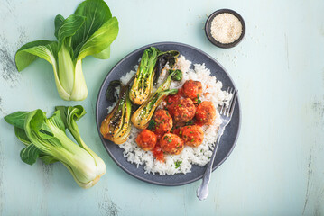Bowl of chicken meatballs in sweet chili sauce with rice and baby Pak choi or Bok choy (Chinese...