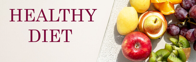 Assortment of fresh organic fruit on white table with text healthy diet. Healthy food concept.fresh summer salad of various fruits.Vitamins natural nutrition concept. web banner