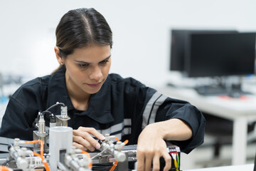 Female engineer training Programmable logic controller with AI robot training kit and mechatronics...