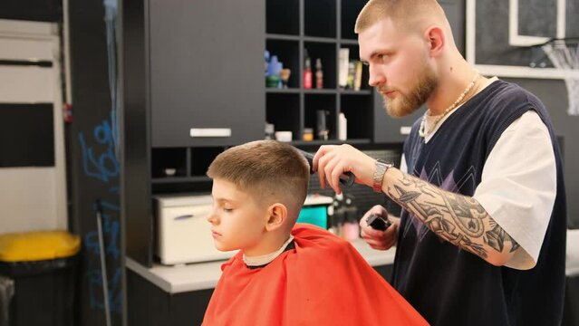 A teenage boy gets a haircut in a barber shop, a child's haircut with scissors