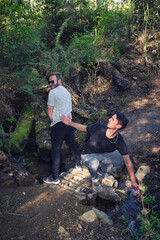 Man polluting water by peeing in stream. Friend scolds him and he can't carry his water bottle.