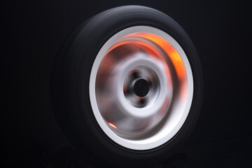 long exposure photography in motion spinning car titanium rims in blurry light	